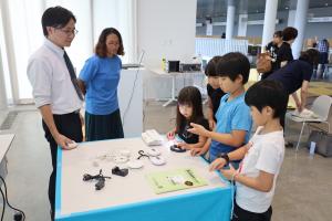 休憩時間中に熱心に機器を見る子ども達