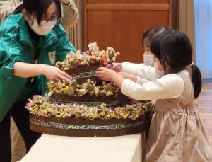 ドライフラワーのケーキに花を指す参加者