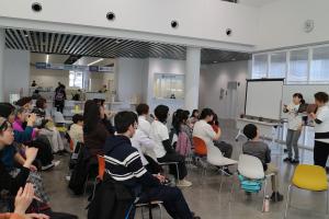 全体写真：イベント会場の様子（講師が前に立ち、参加者が手話を学ぶ）