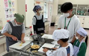 写真：小学生と中学生が共同で調理実習を行う様子